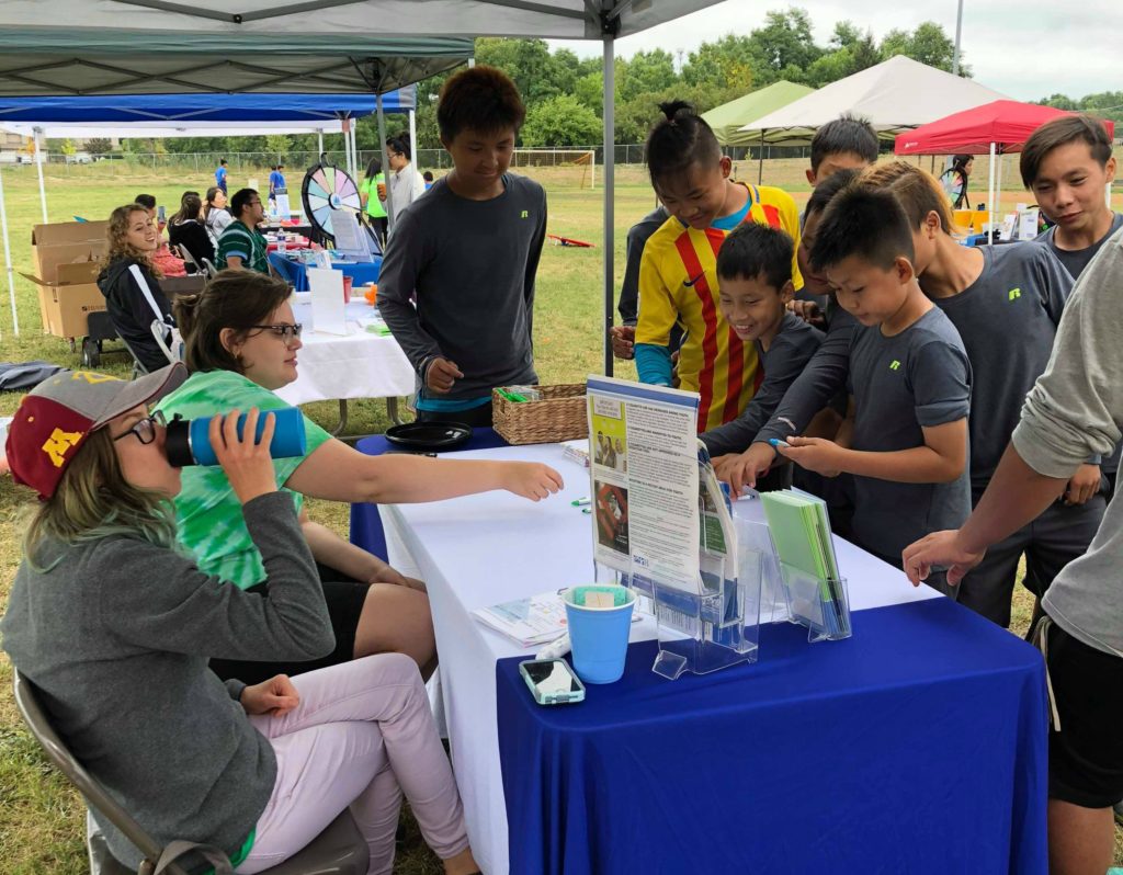 A Karen boys soccer team visits an info booth about raising the legal tobacco age to 21