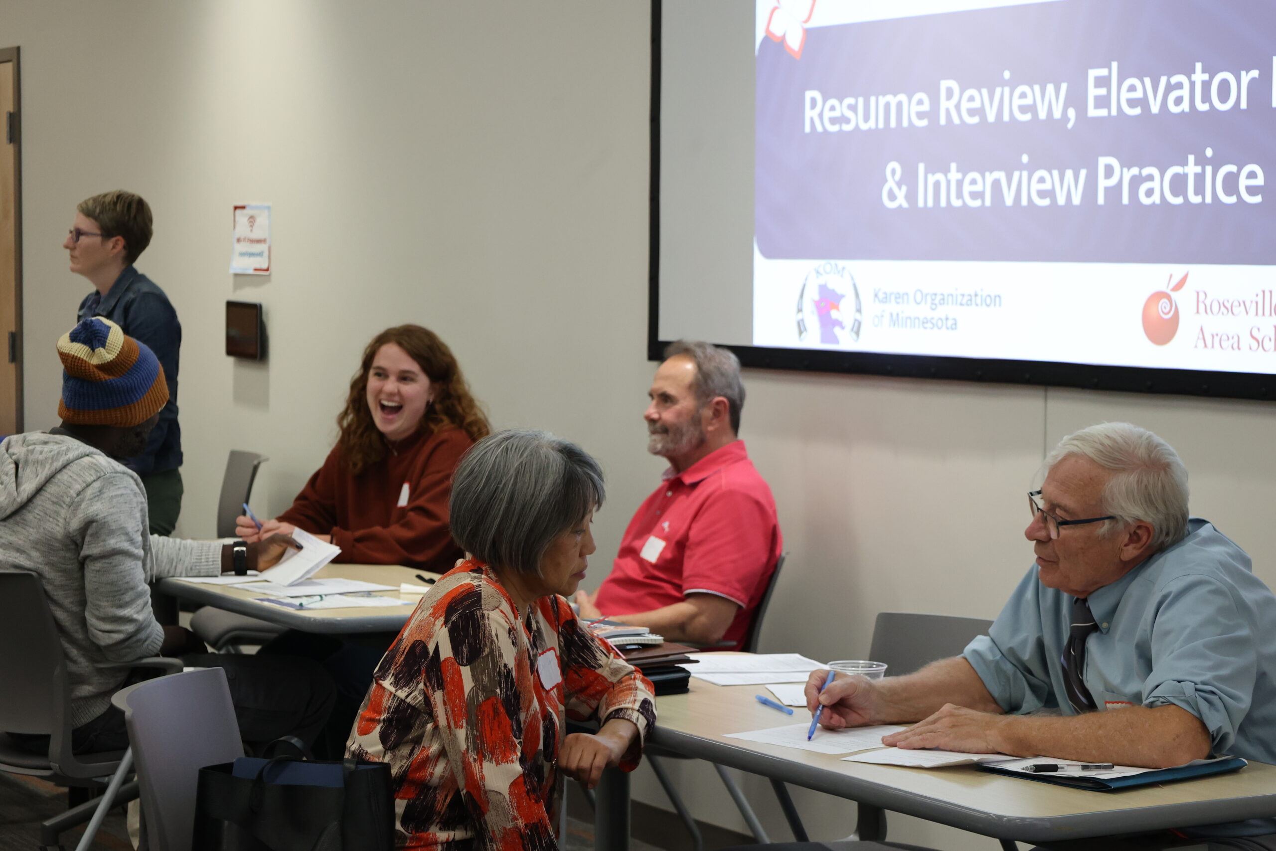 Volunteers sit at tables with attendees and conduct practice interviews at our Bilingual Professionals Job Fair in October.