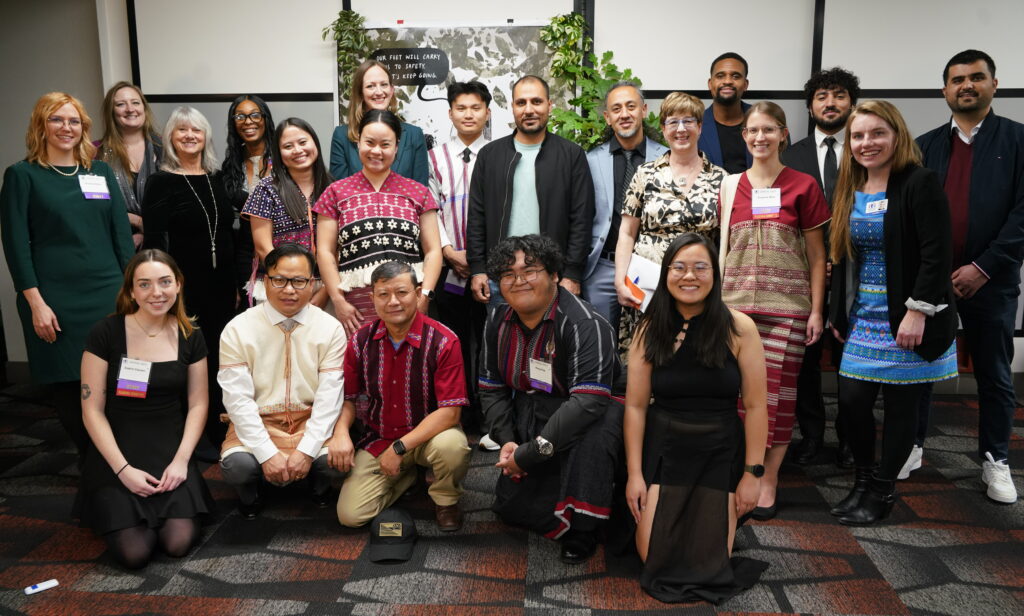 Group photo of KOM staff members posing in two rows.