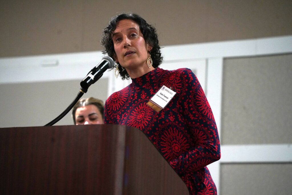 Katie Freeman speaking at the 2024 Annual KOM Gala at a podium.