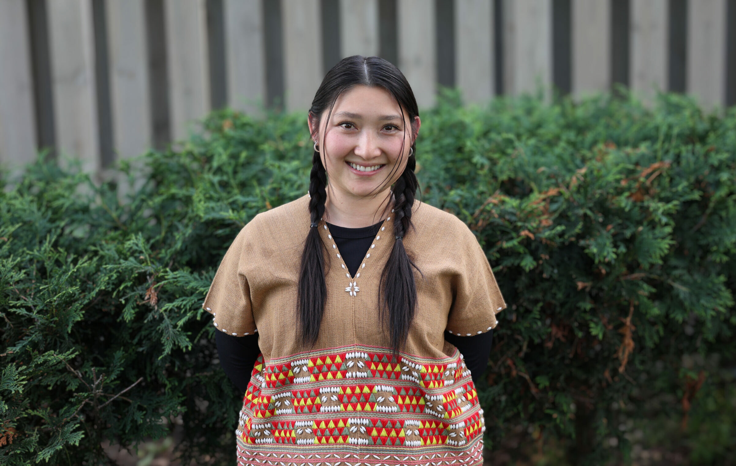 Individual photo of Juju Lay standing outside and smiling towards the camera.