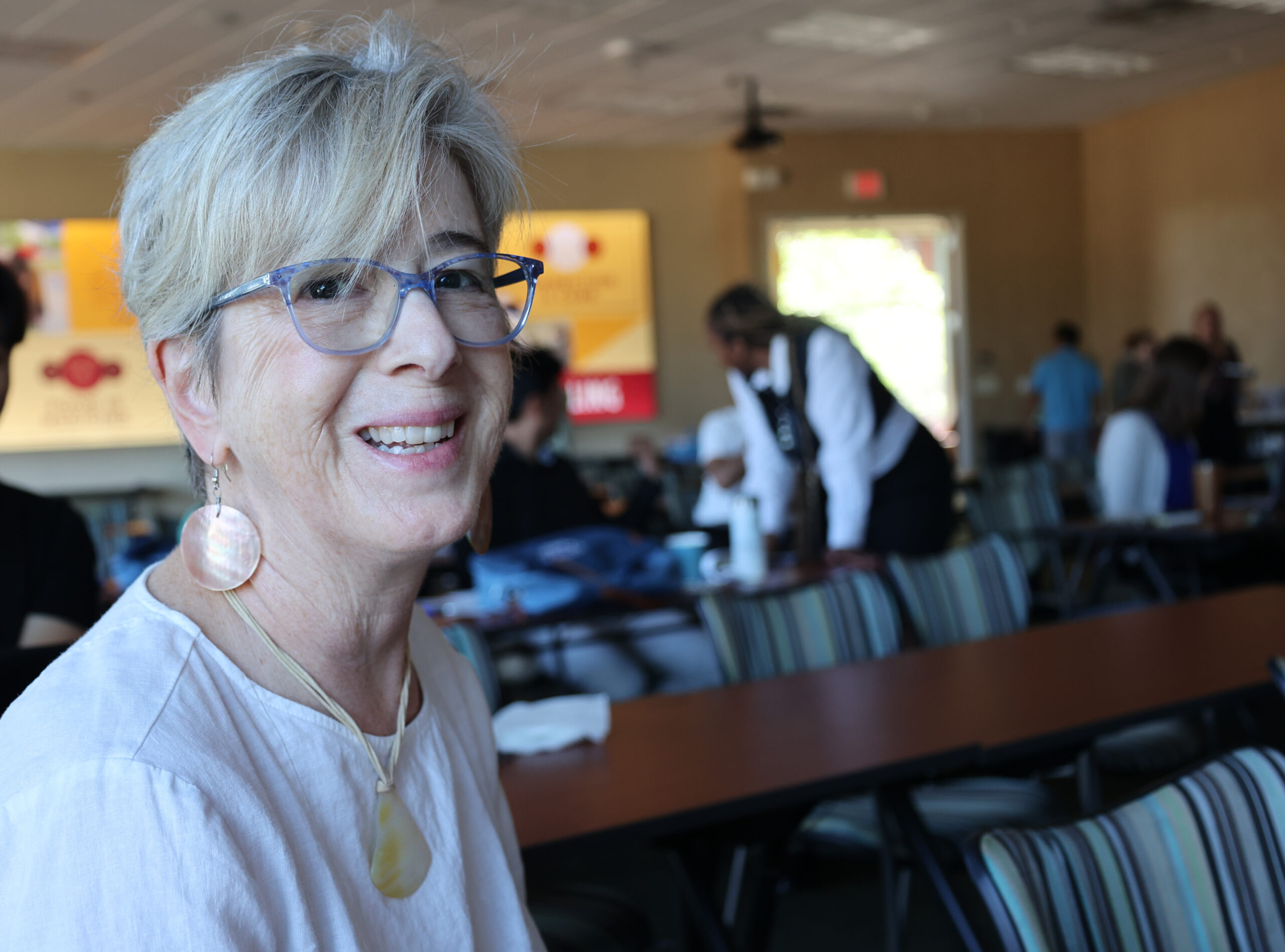 Alice Buckner smiling towards the camera at a staff meeting.
